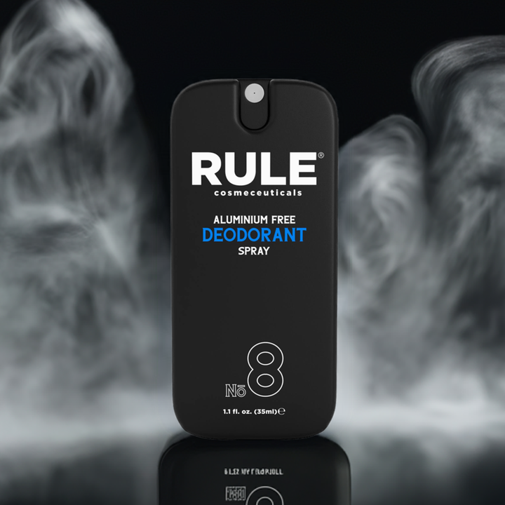 Rule Cosmeceuticals No. 8 Aluminum-Free Deodorant Spray bottle displayed on a glossy surface with a swirling, smoky backdrop. A sleek and effective deodorant for all-day freshness and confidence.